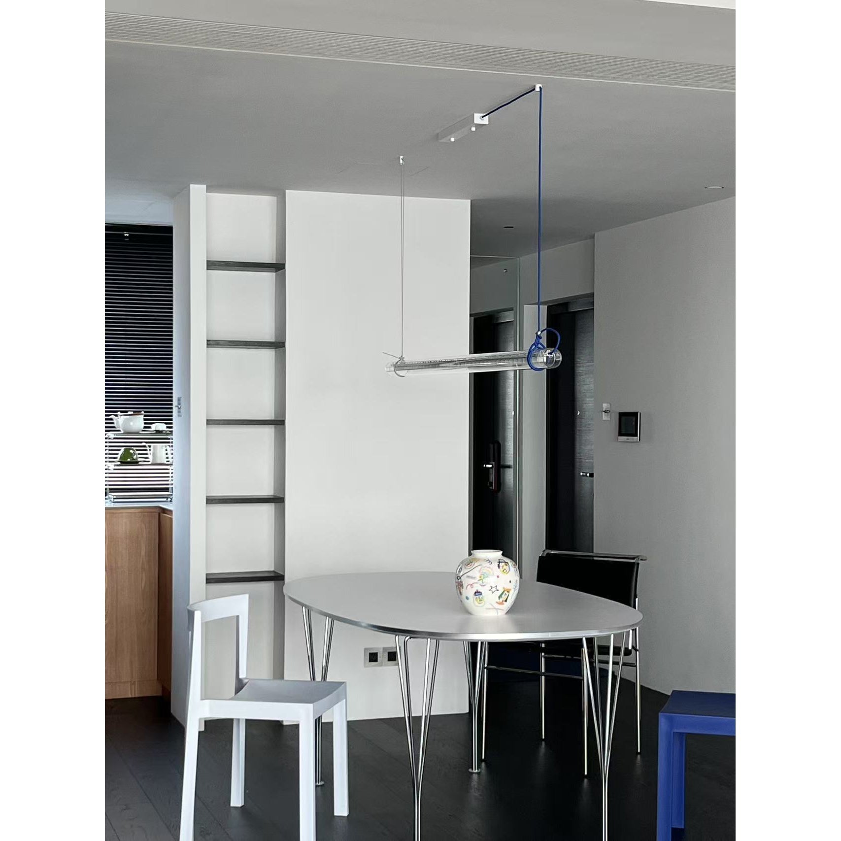The red tubular lamp styled against a light-colored wall.