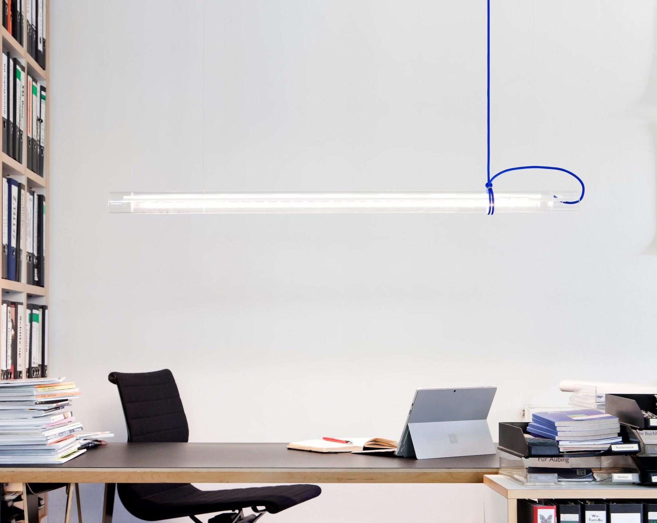 Blue tubular linear LED pendant lamp casting a cool glow.
