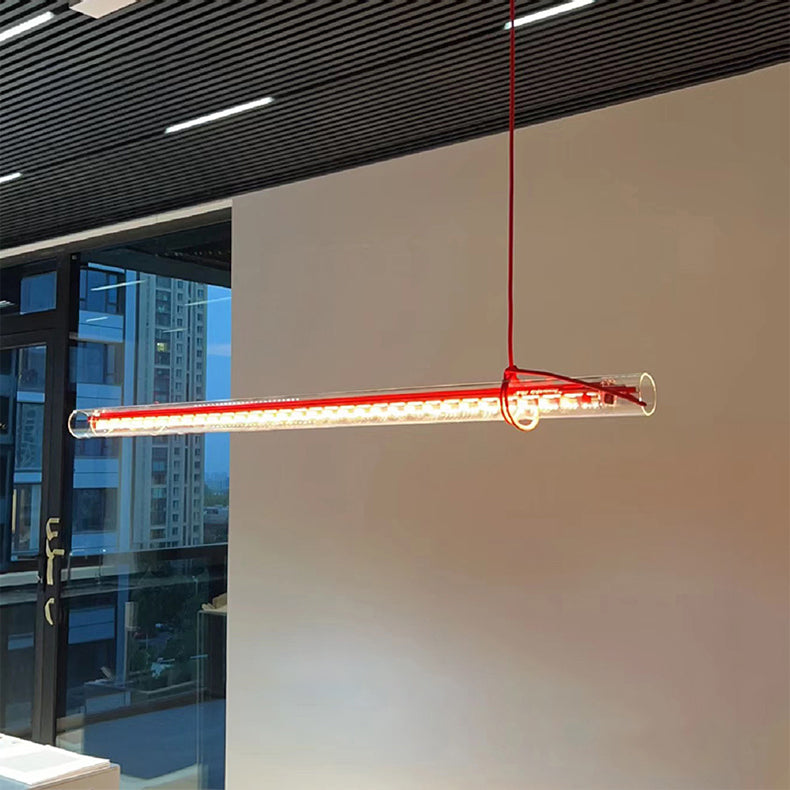 A row of clear tubular pendant lamps over a kitchen island.