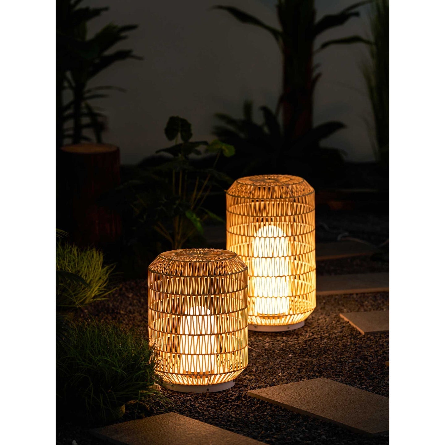 Two Tulum Lanterns of different sizes on a stone patio.