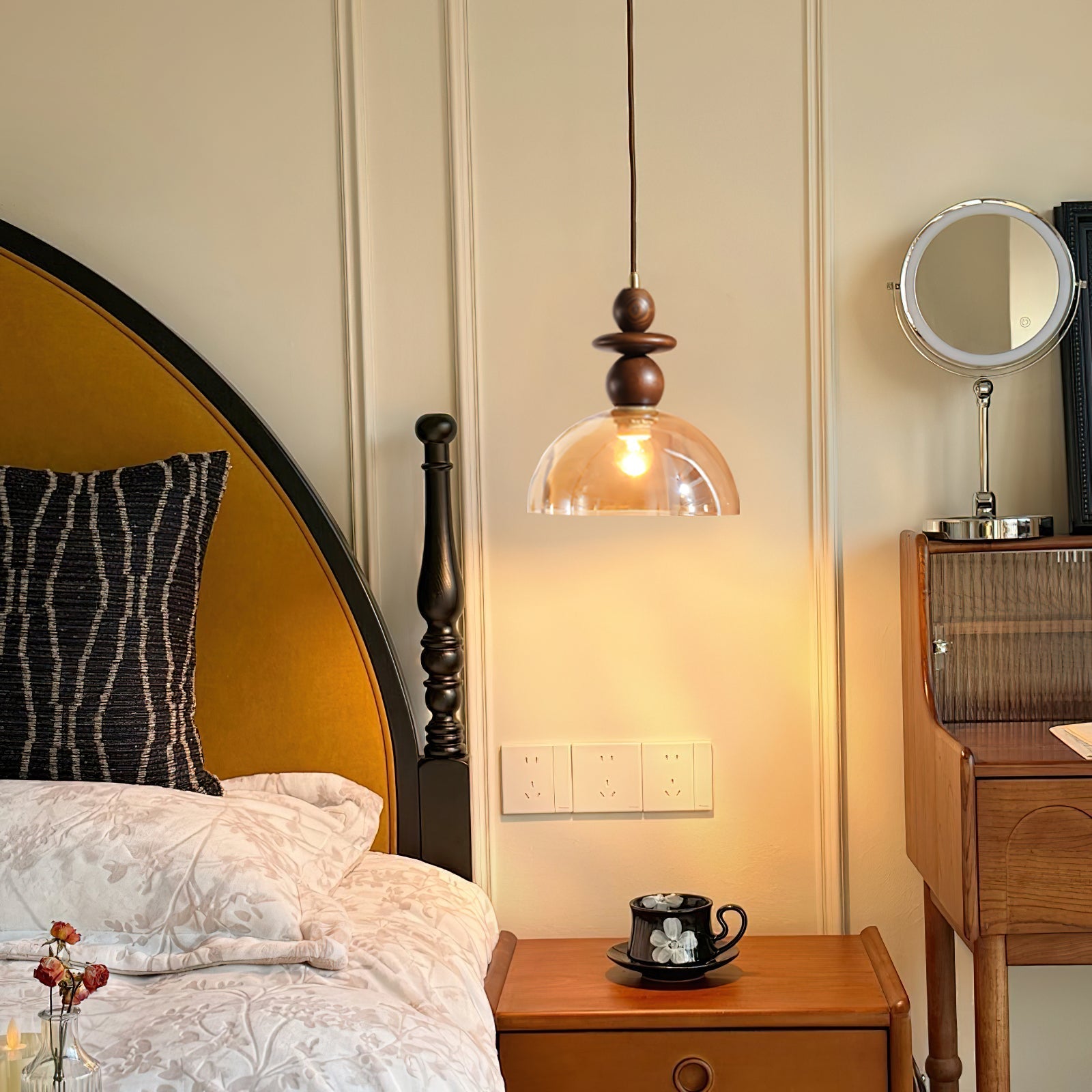 The Valeska Pendant Light hanging over a bedside table.