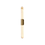 Velin alabaster tube wall sconce with gold cuff against a neutral wall.