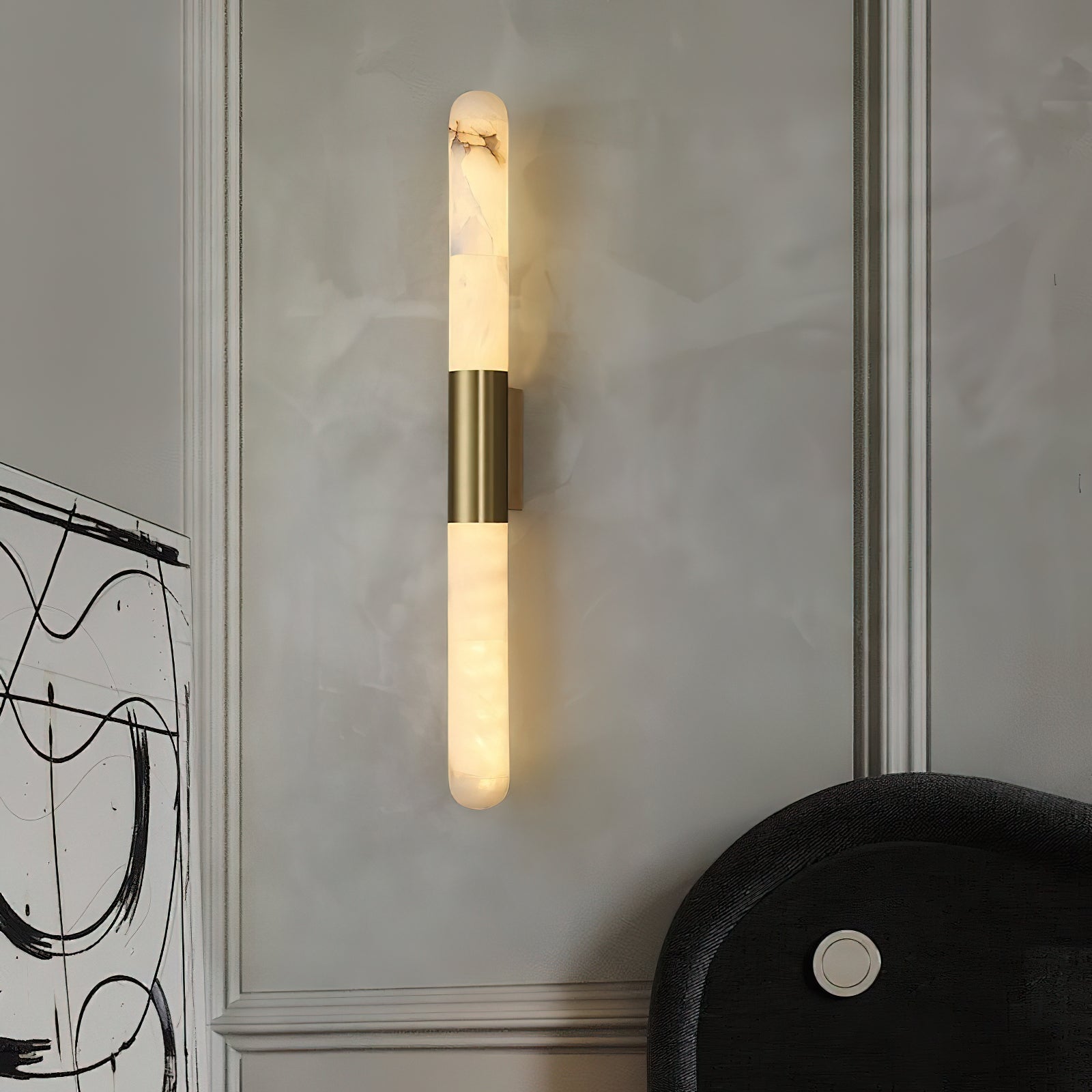 The Velin wall sconce shown illuminated, casting a warm, ambient glow.