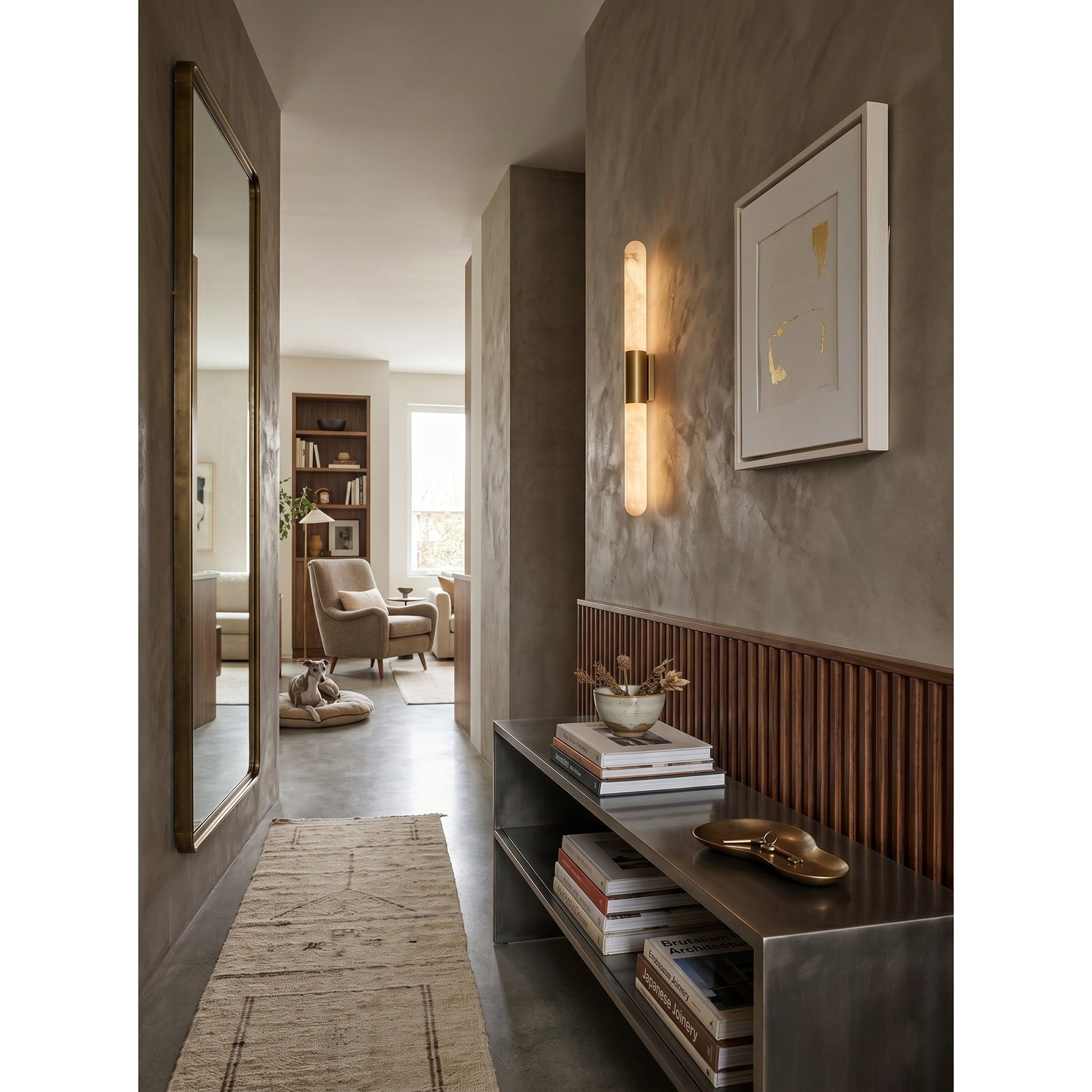 Lifestyle image of the Velin sconce in a moody powder room setting.