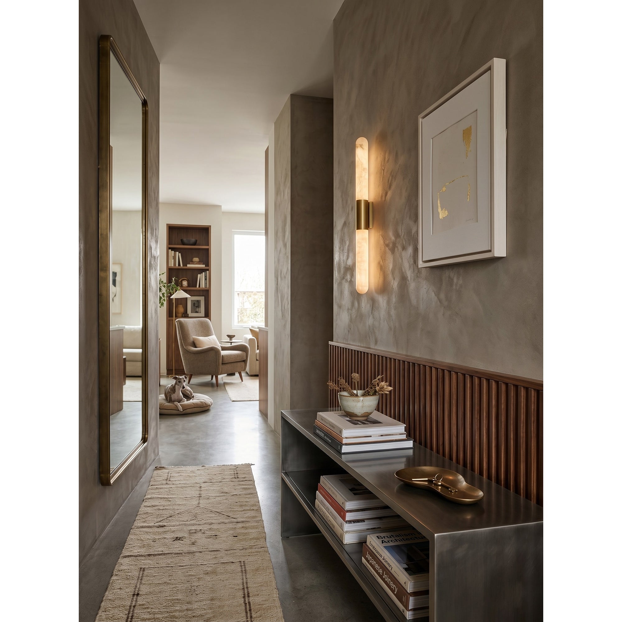Lifestyle image of the Velin sconce in a moody powder room setting.