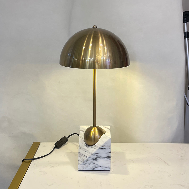The black Venus Table Lamp in an office setting on a desk.