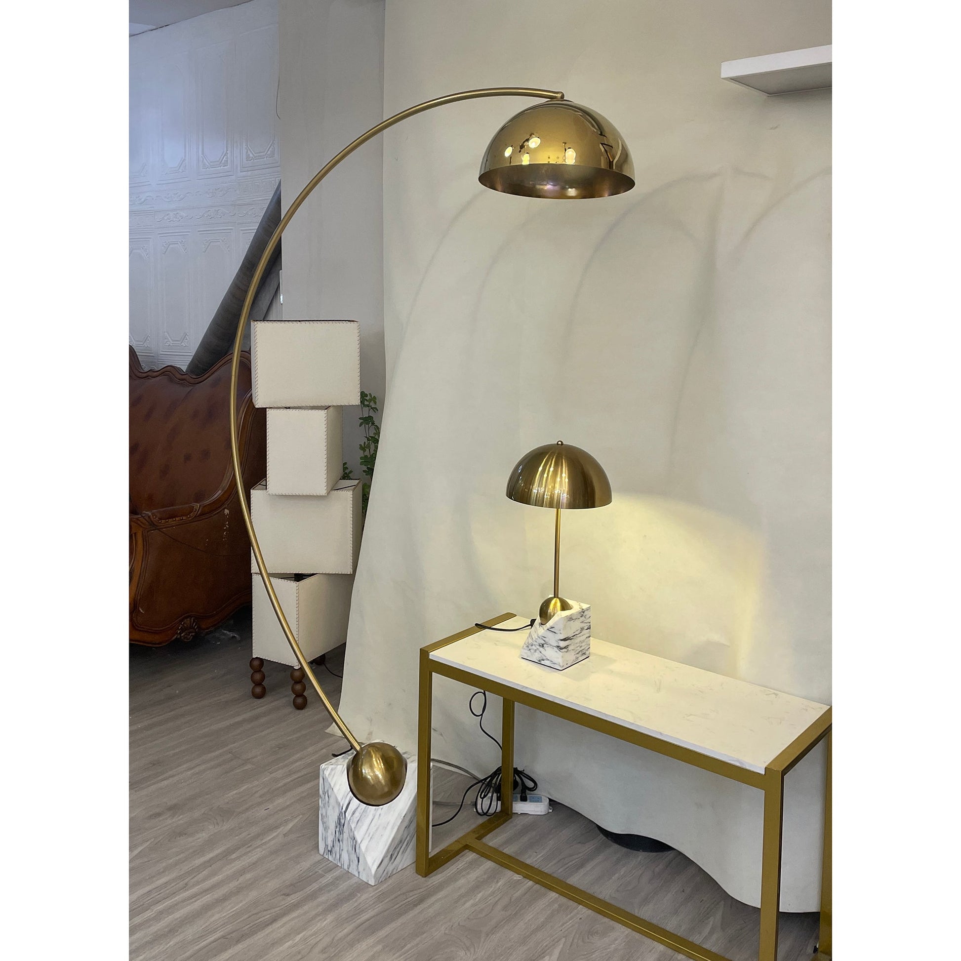 The gold Venus Table Lamp against a dark background to highlight its finish.