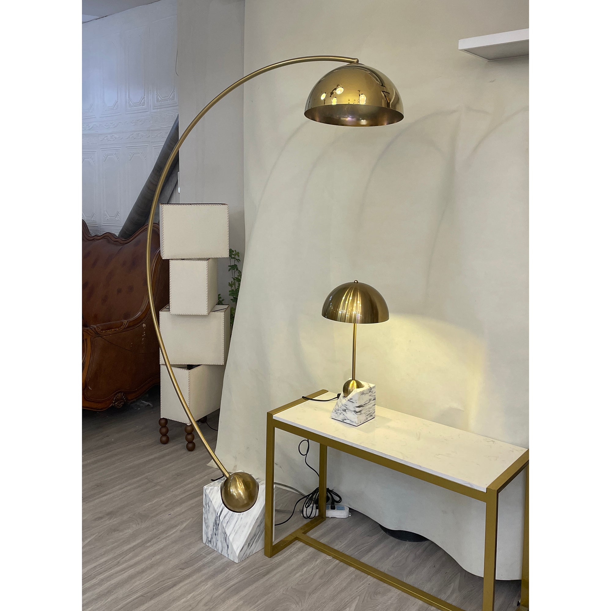 The gold Venus Table Lamp against a dark background to highlight its finish.