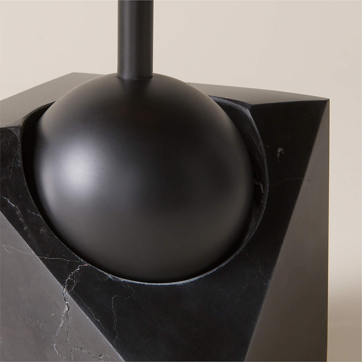 A detail shot focusing on the junction between the metal body and the marble base.