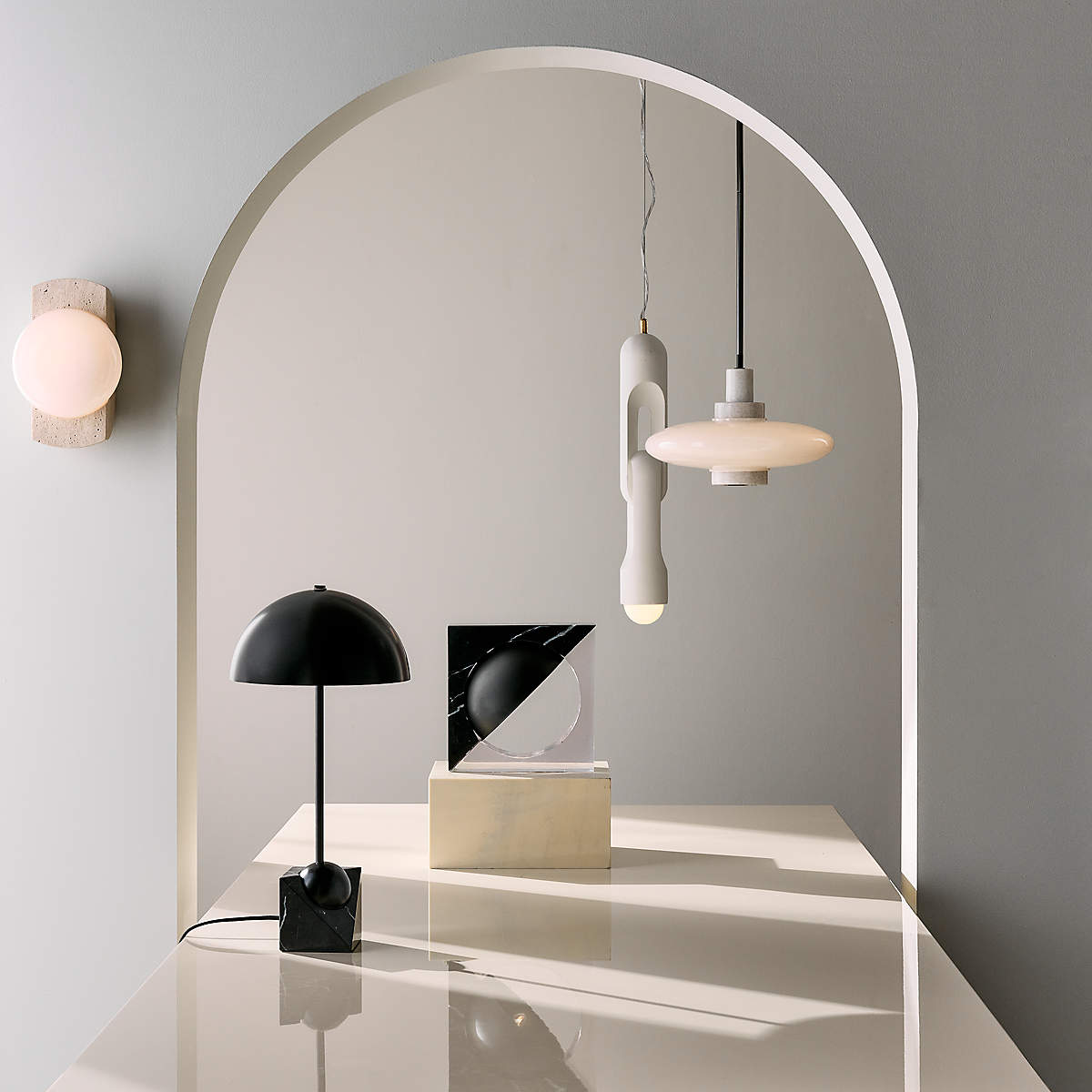 The white Venus Table Lamp on a nightstand in a bedroom setting.