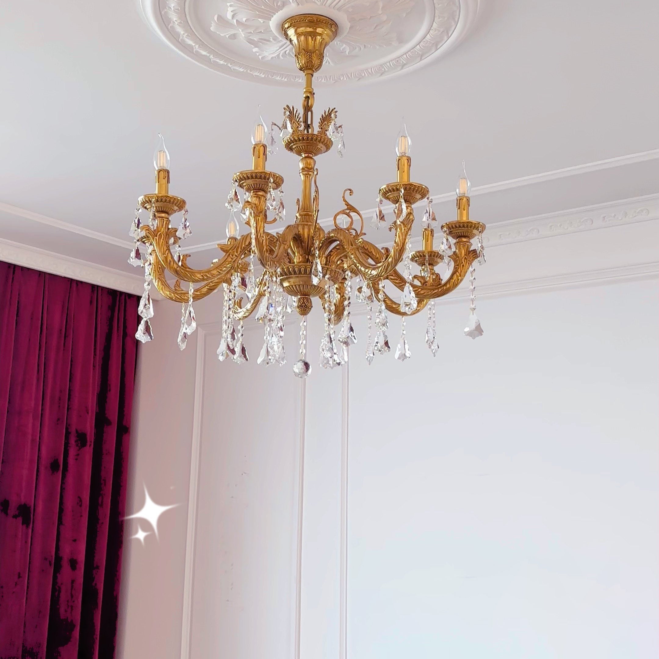 The warm glow of the chandelier against a dark wall.