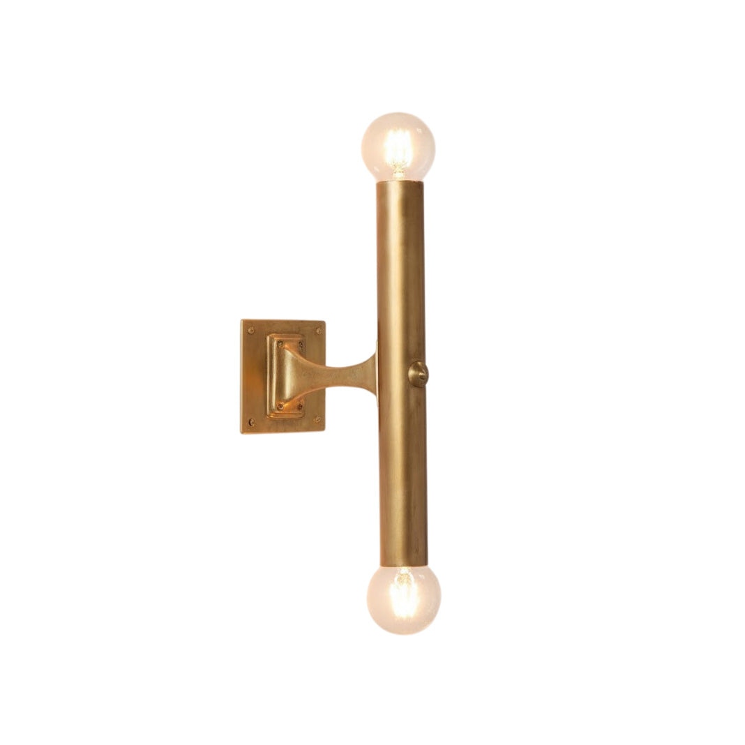 Vesper Wall Lamp in a brass finish against a neutral wall.