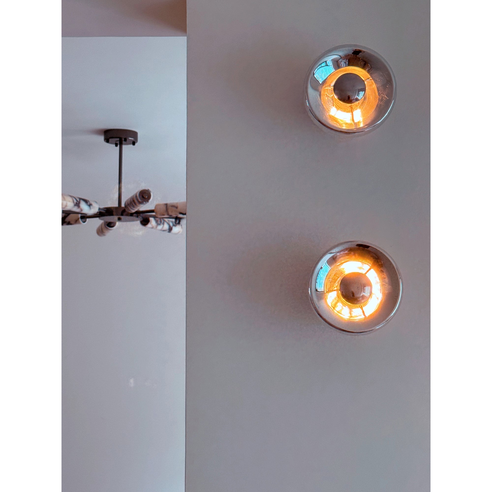 The chrome Void Surface Sconce illuminating a hallway.