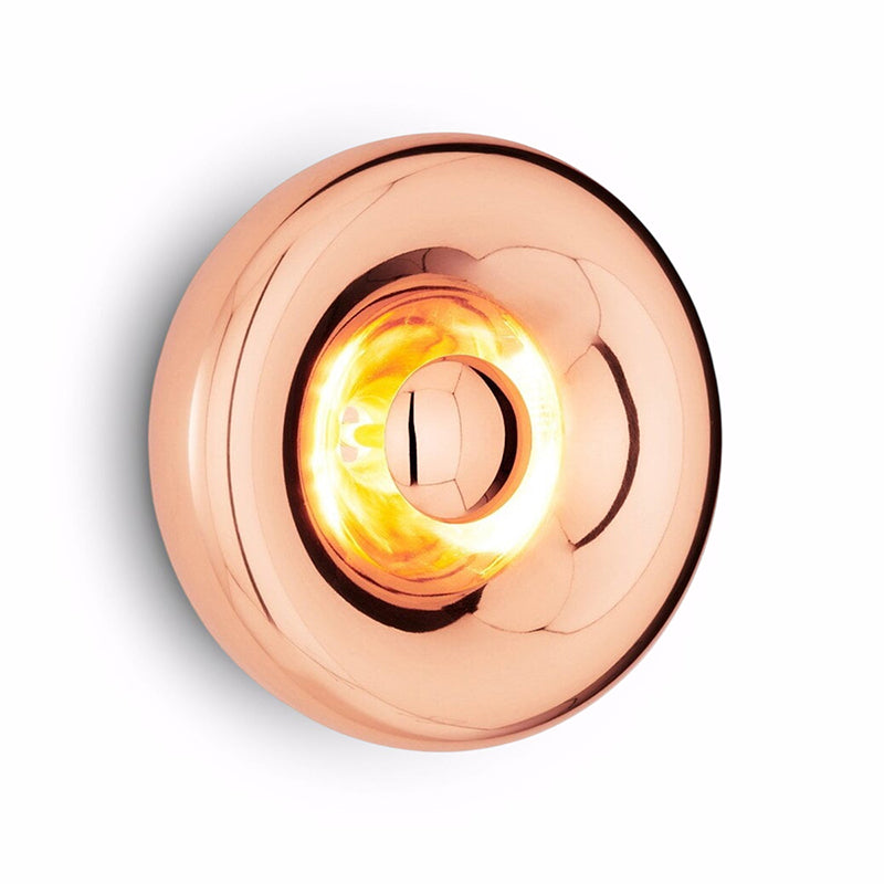 The gold Void Sconce installed in a bedroom setting.