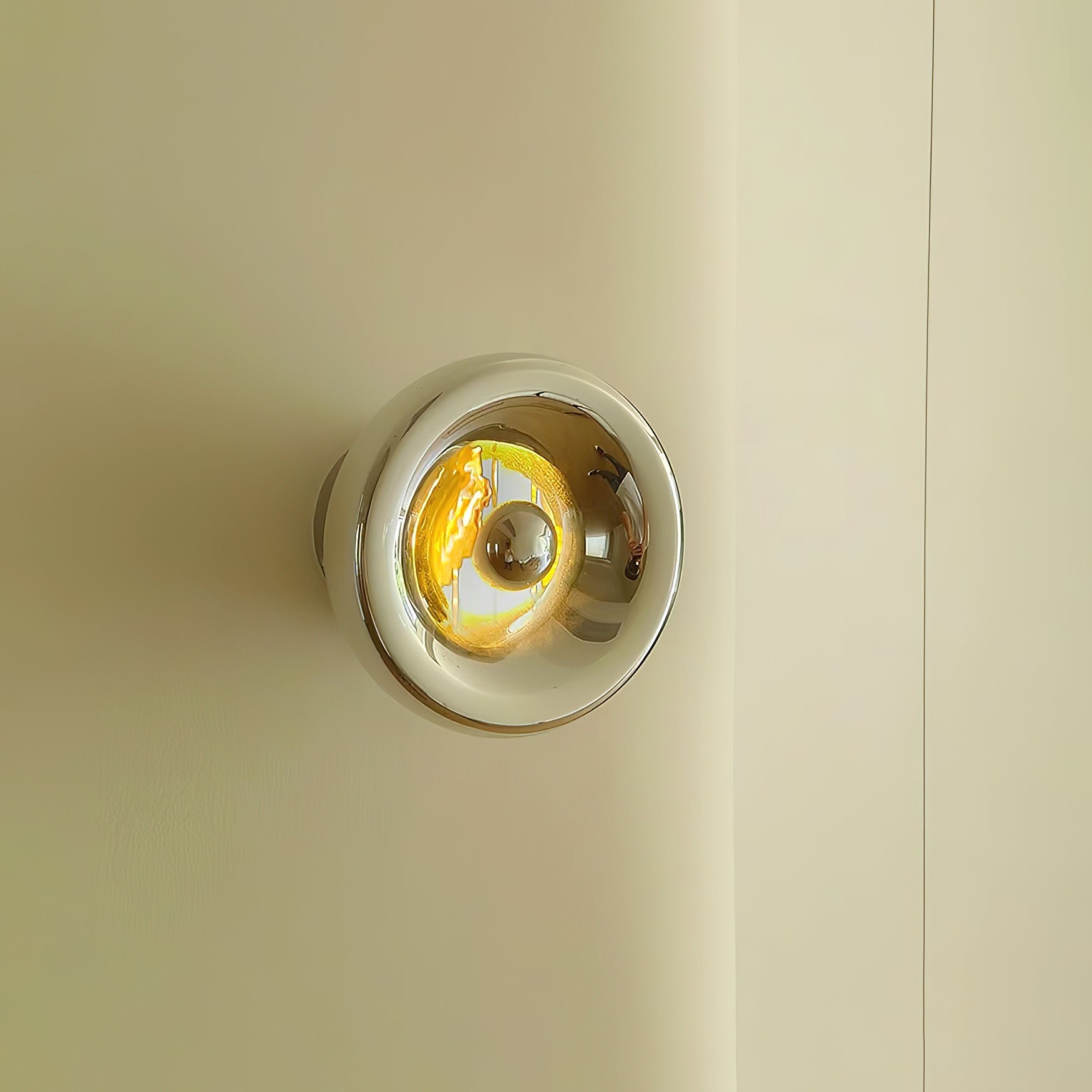 Close-up of the Void Surface Sconce's glass shade and metal backplate.