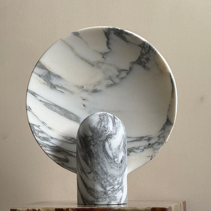 White marble lamp on a side table next to a sofa.