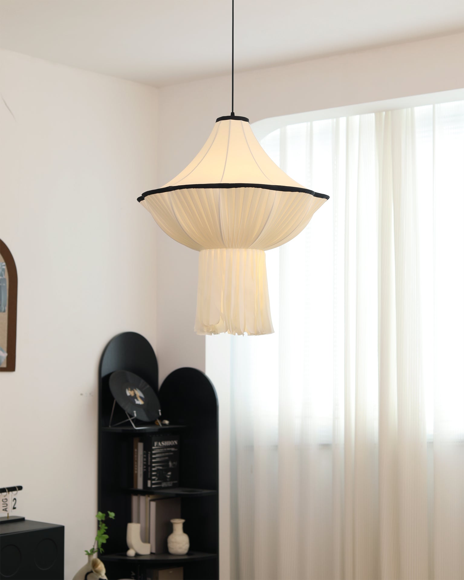 The black version of the Wildon Pendant Light hanging in a minimalist space.