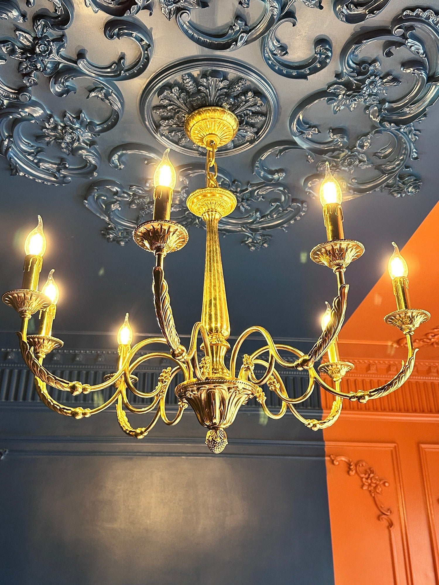 Close-up of the candle-style light holders on the brass chandelier.