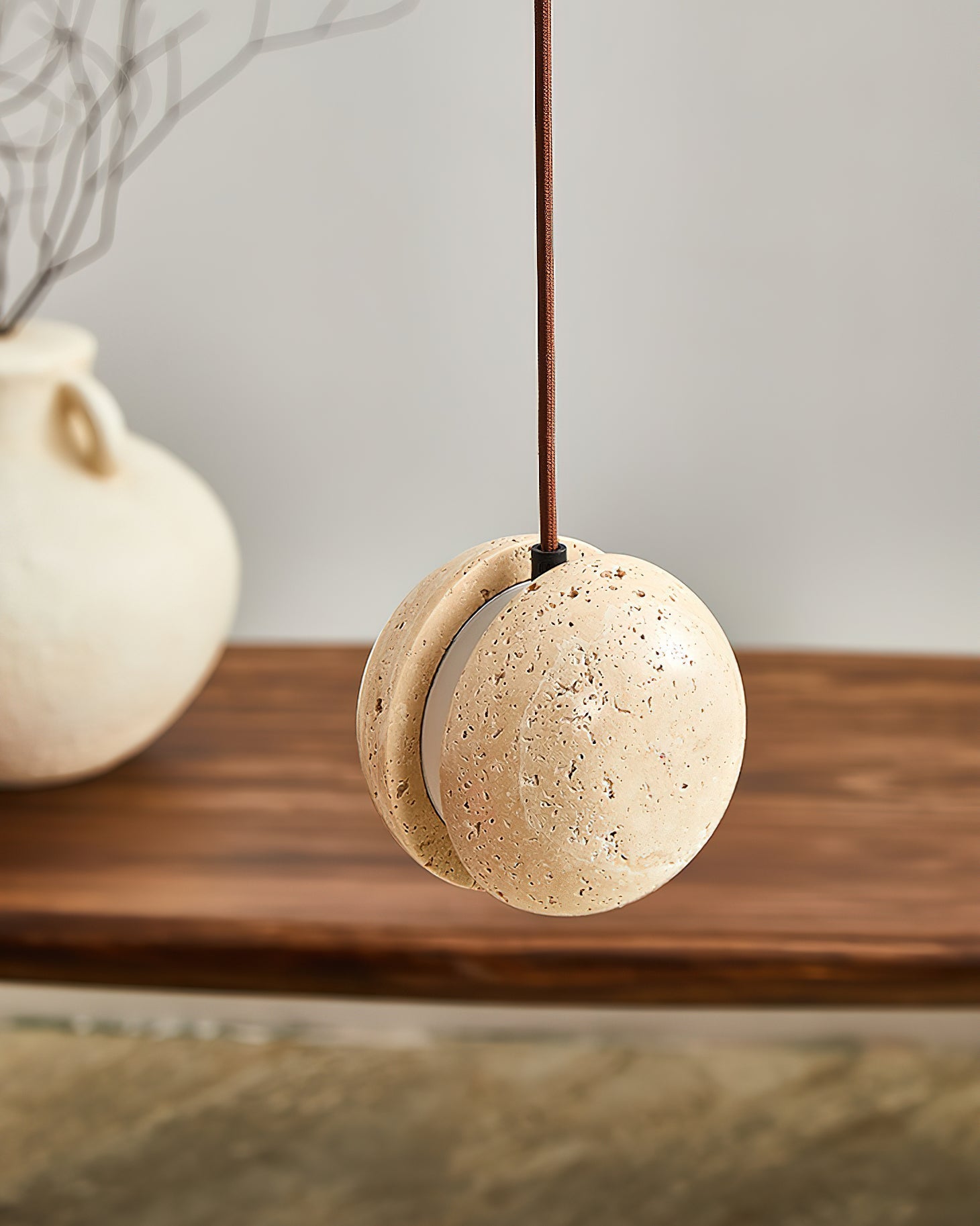 Detail shot of the split-sphere design of the travertine pendant.