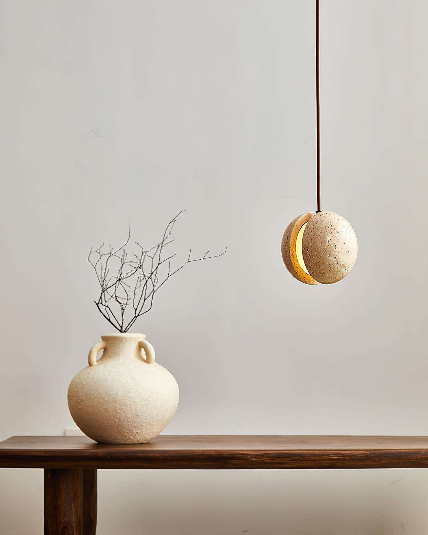 The Wisteria Pendant Lamp illuminated, showing its warm, glowing core.
