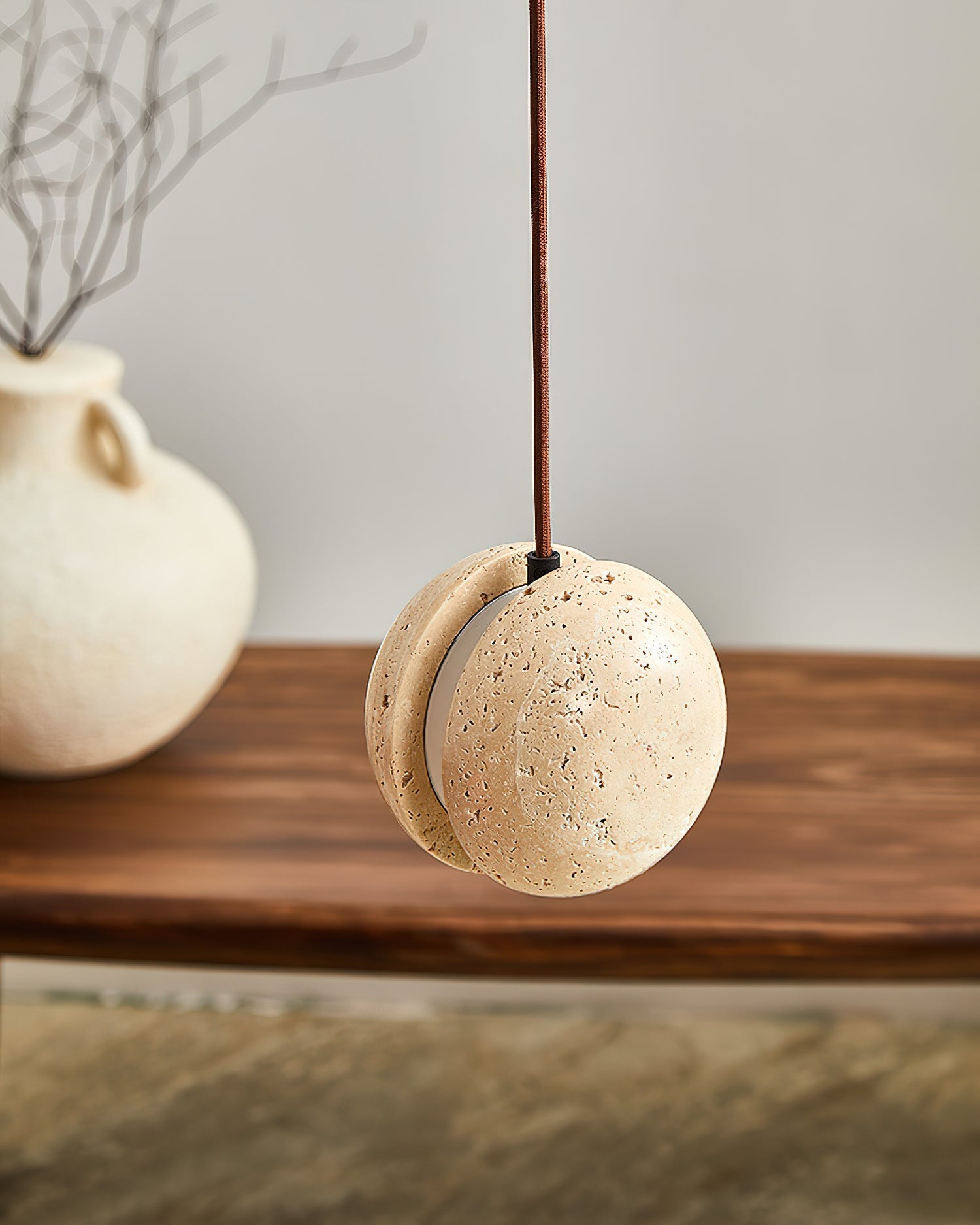 Unlit view of the pendant lamp, showcasing the beige and yellow tones of the travertine.