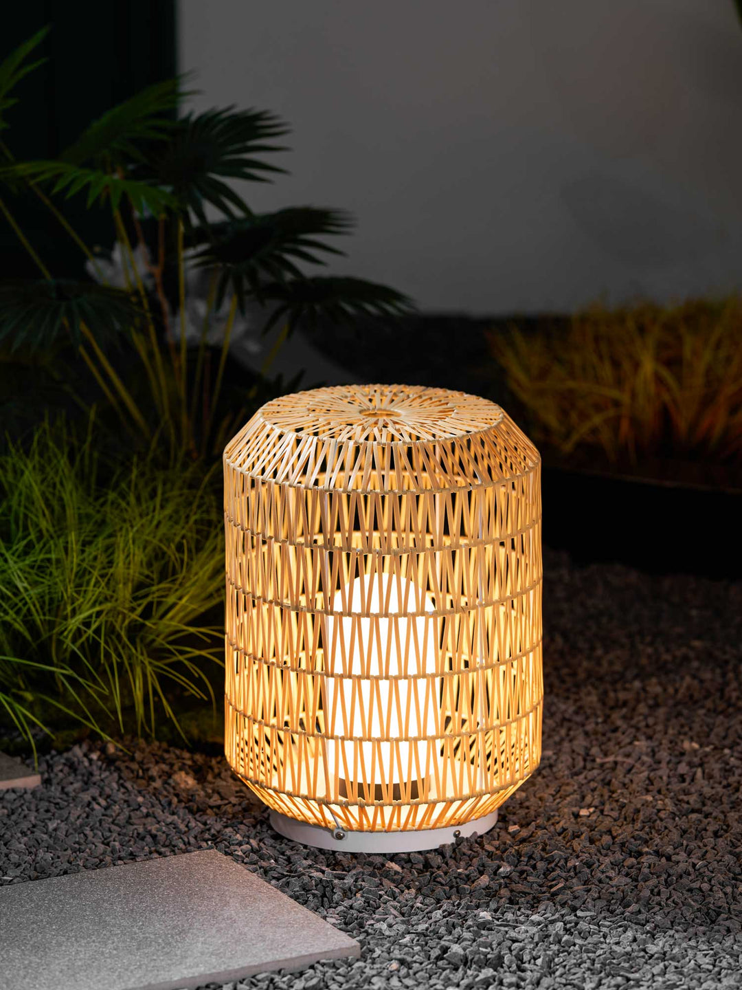 The outdoor lamp shown illuminating a patio setting at dusk.