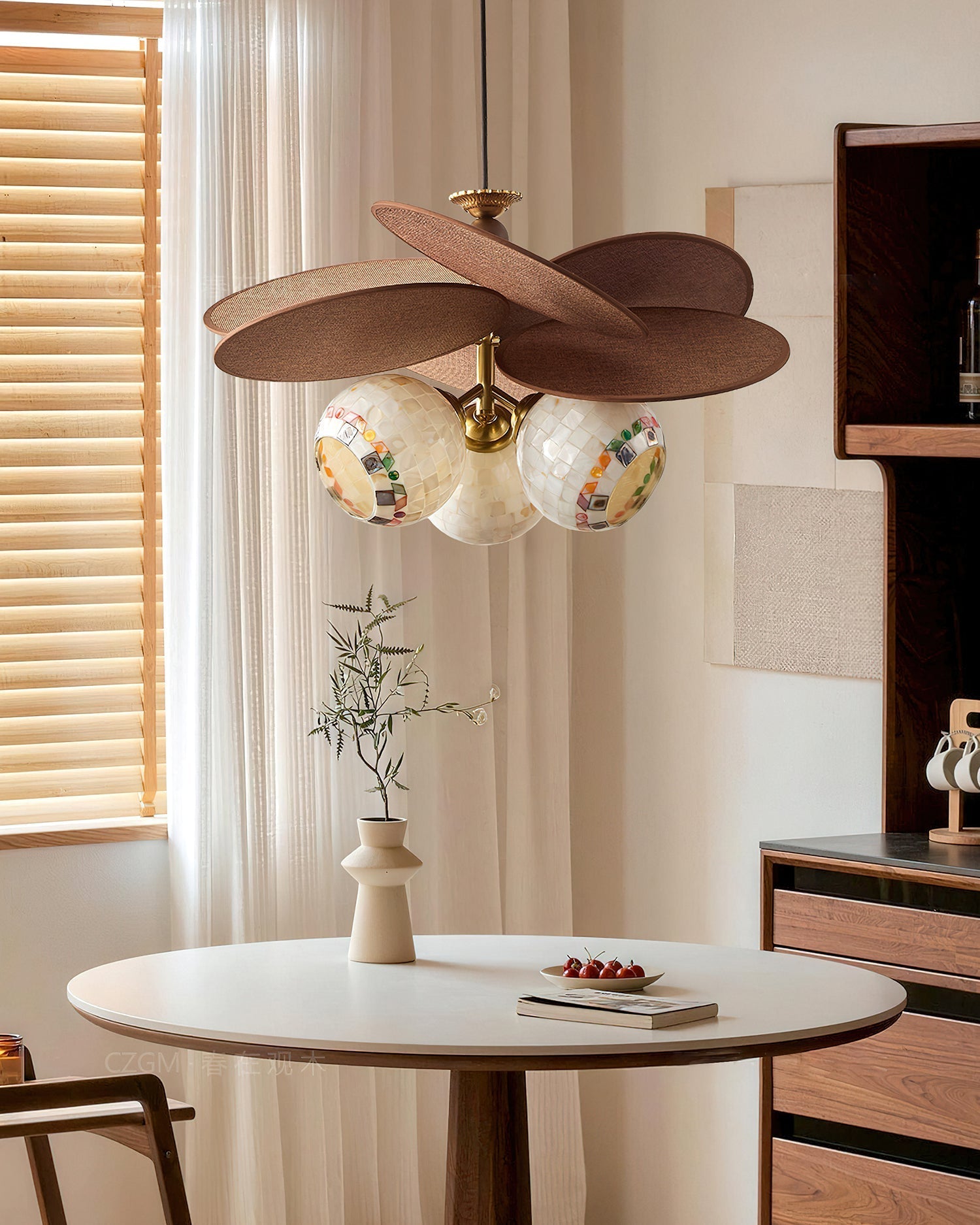 The 3-light model of the Zinnia Flora Chandelier over a dining table.