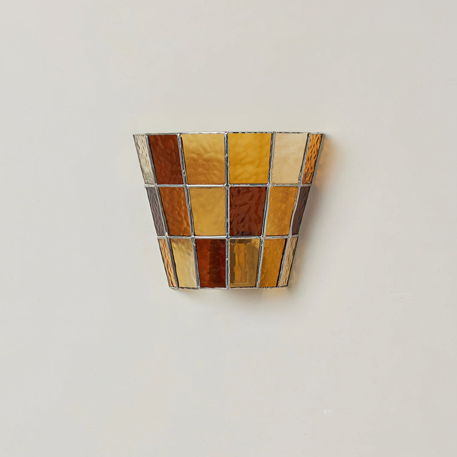 Angled shot of the warm amber glass Zola Sconce.