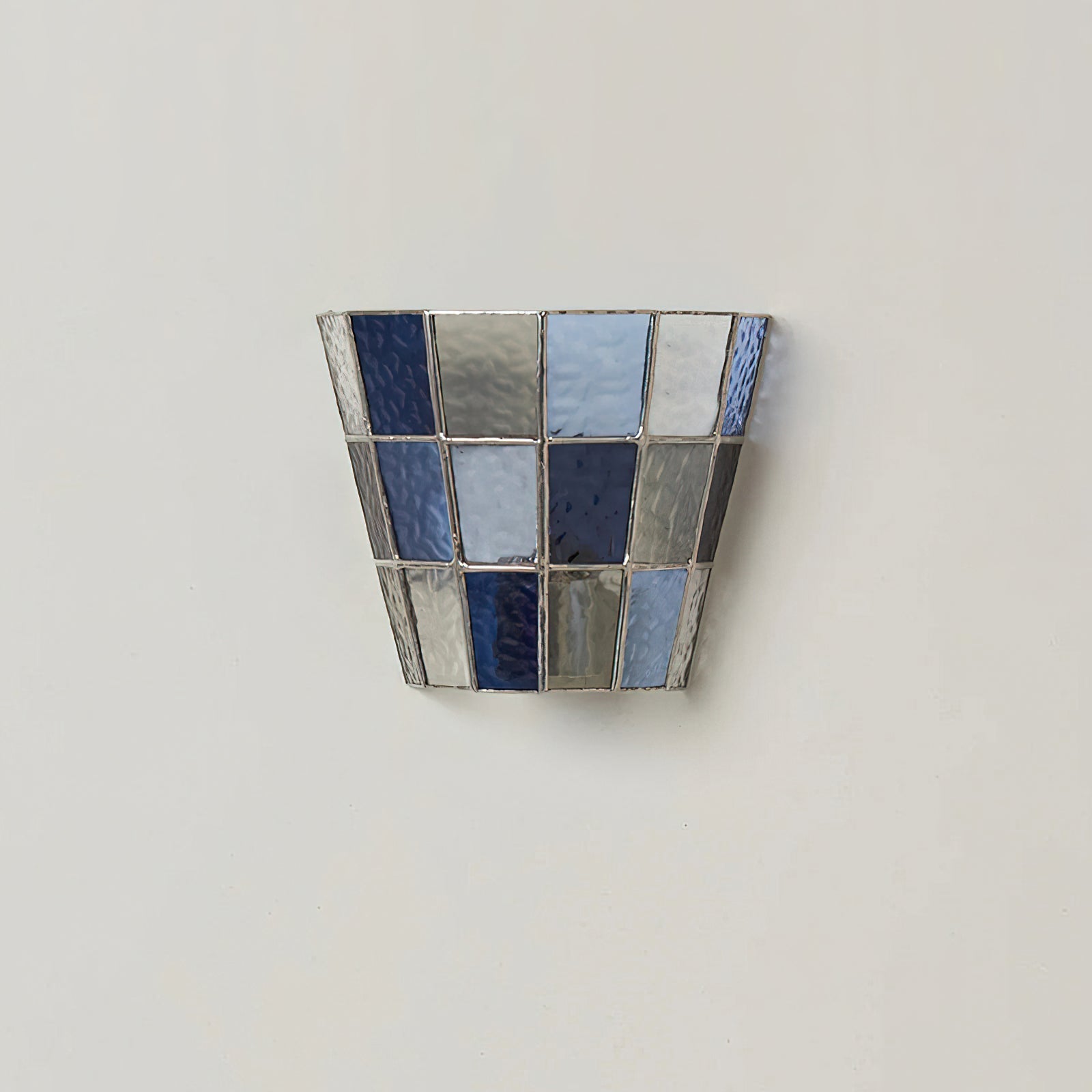 The Zola Sconce in amber glass creating a cozy atmosphere in a dining area.