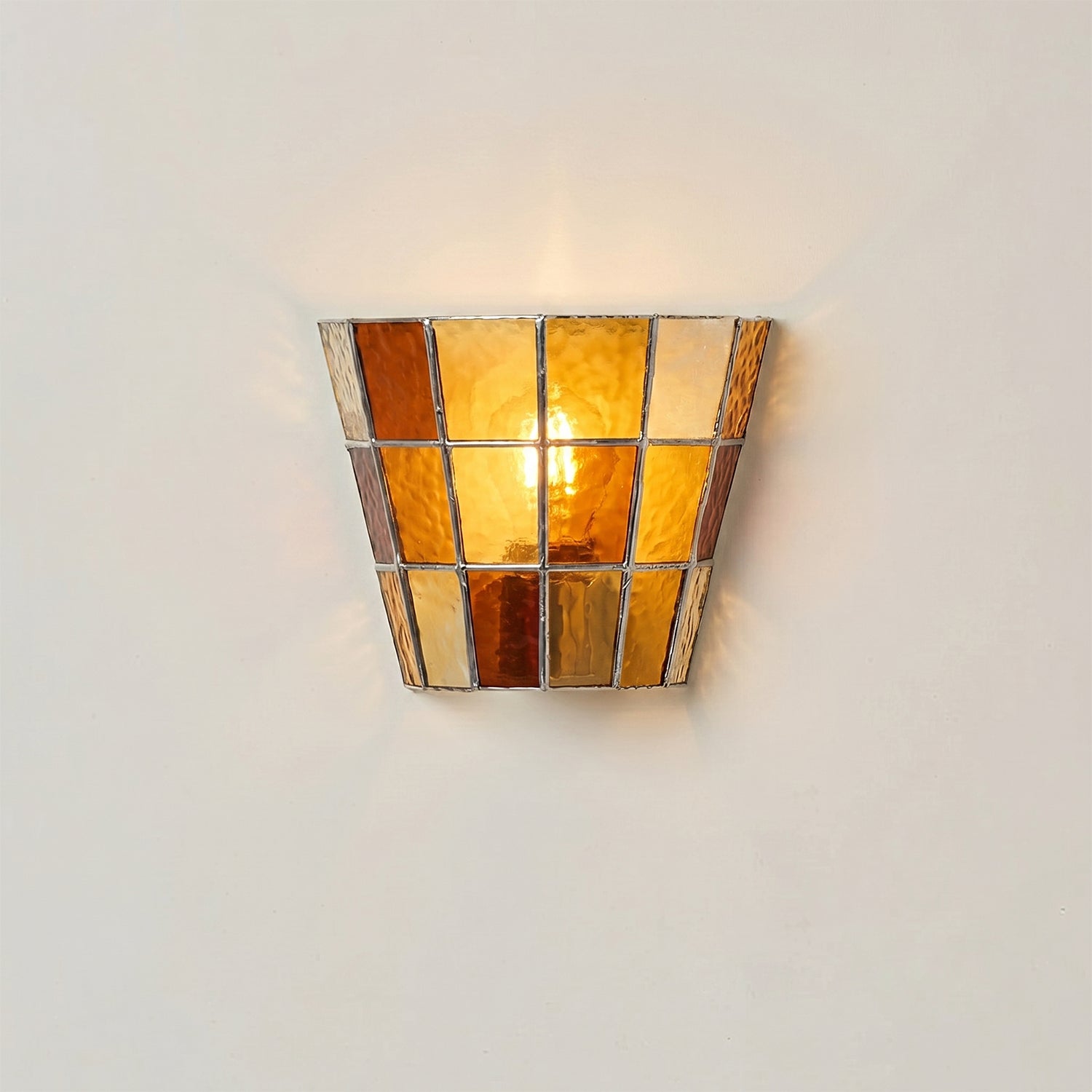 Lifestyle image of the sconce installed next to a reading chair.