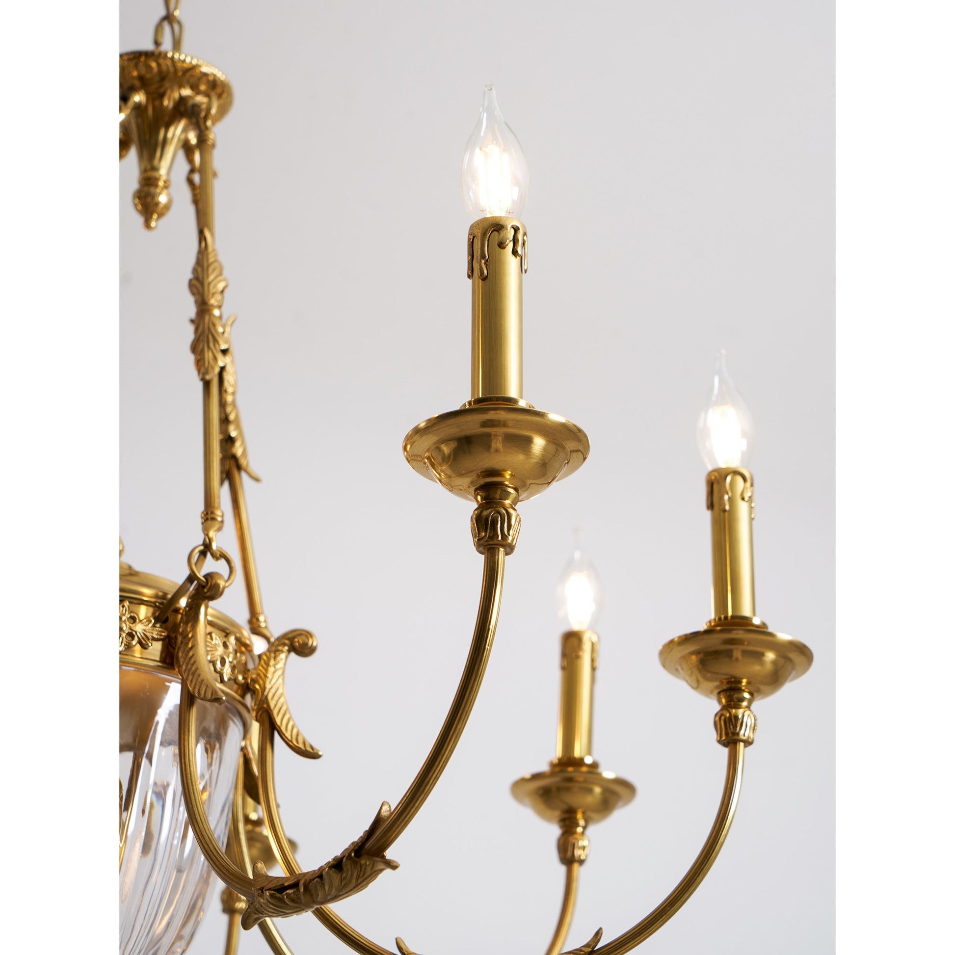 A single scrolled bobeche and flame-tip socket on a chandelier arm.
