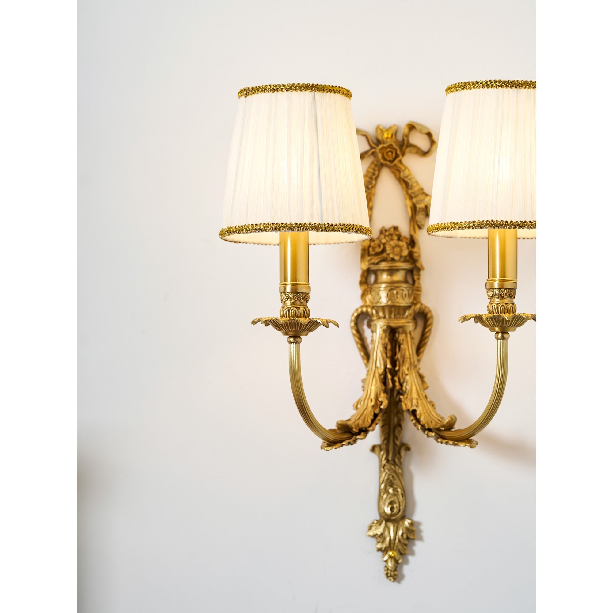 The two-head Claudine Wall Lamp centered over a headboard.
