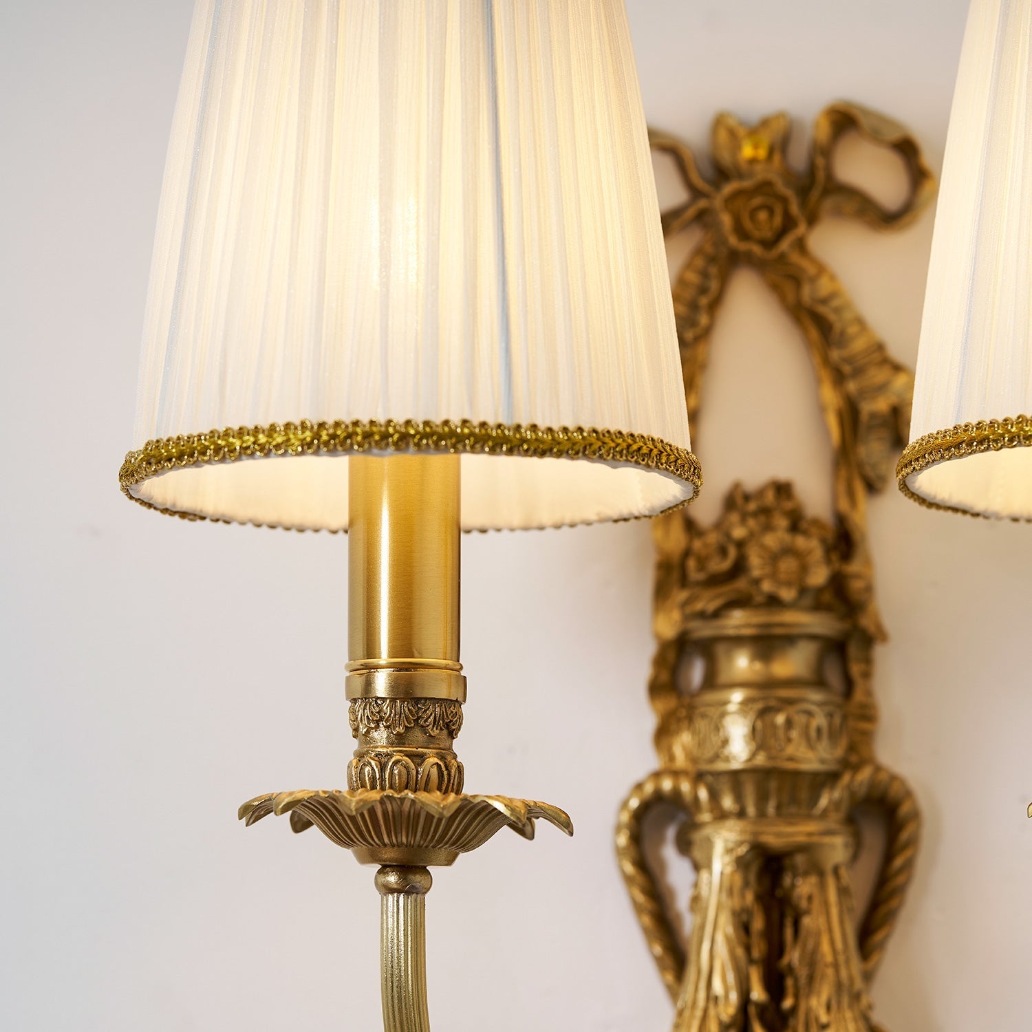 The Claudine Wall Lamp's brass body reflecting light.