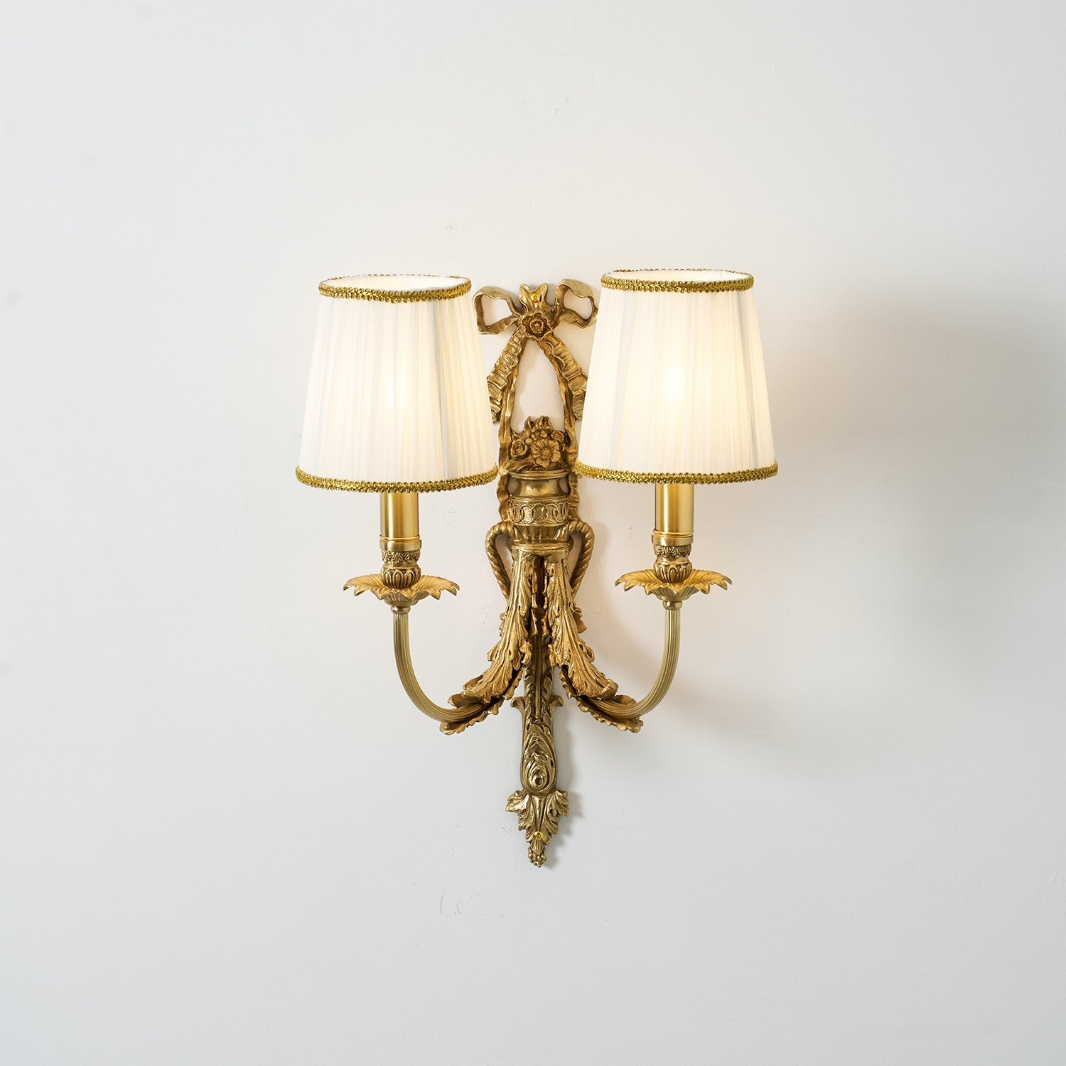 The contrast between the brass metal and white fabric.