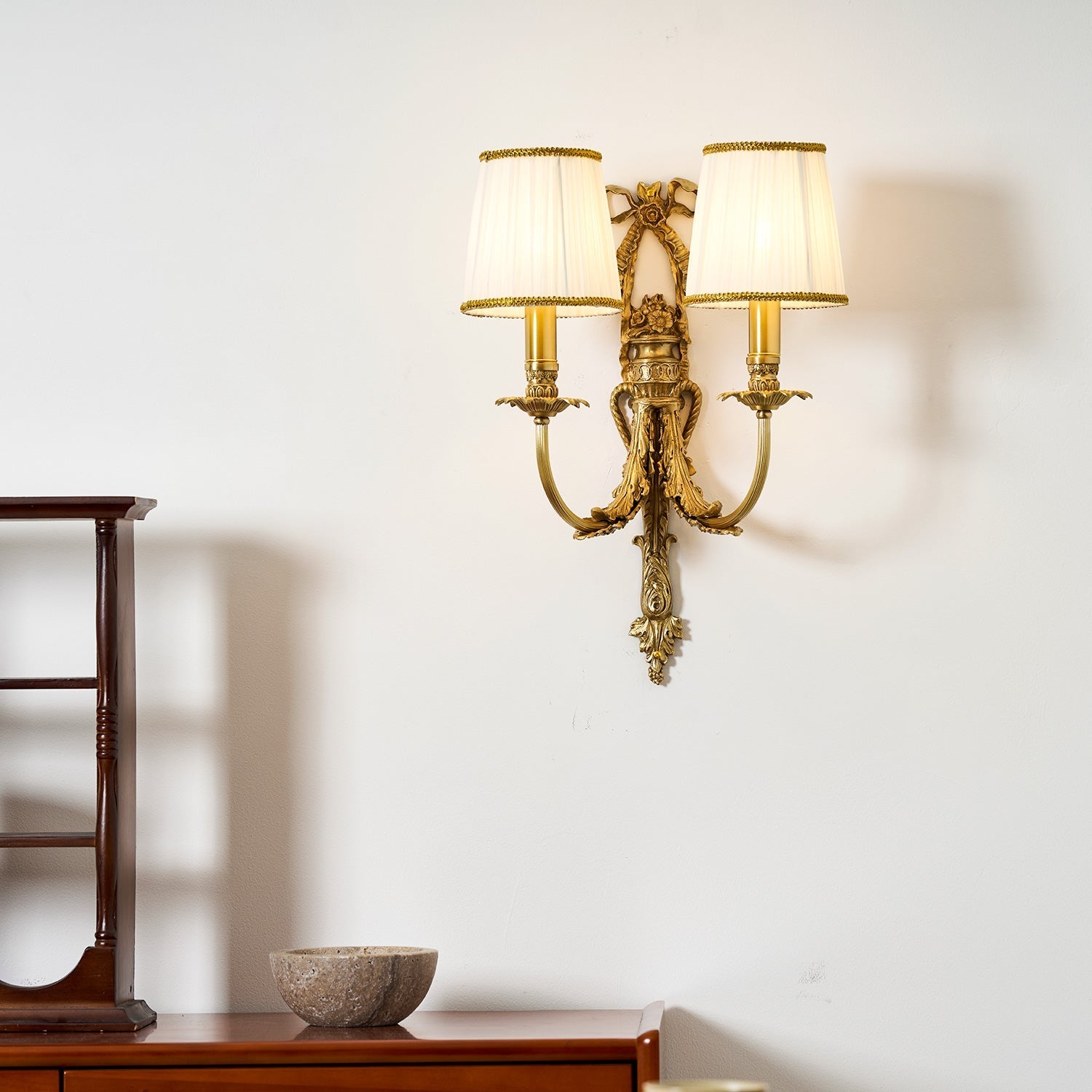 The warm light from the lamp on a textured wall.