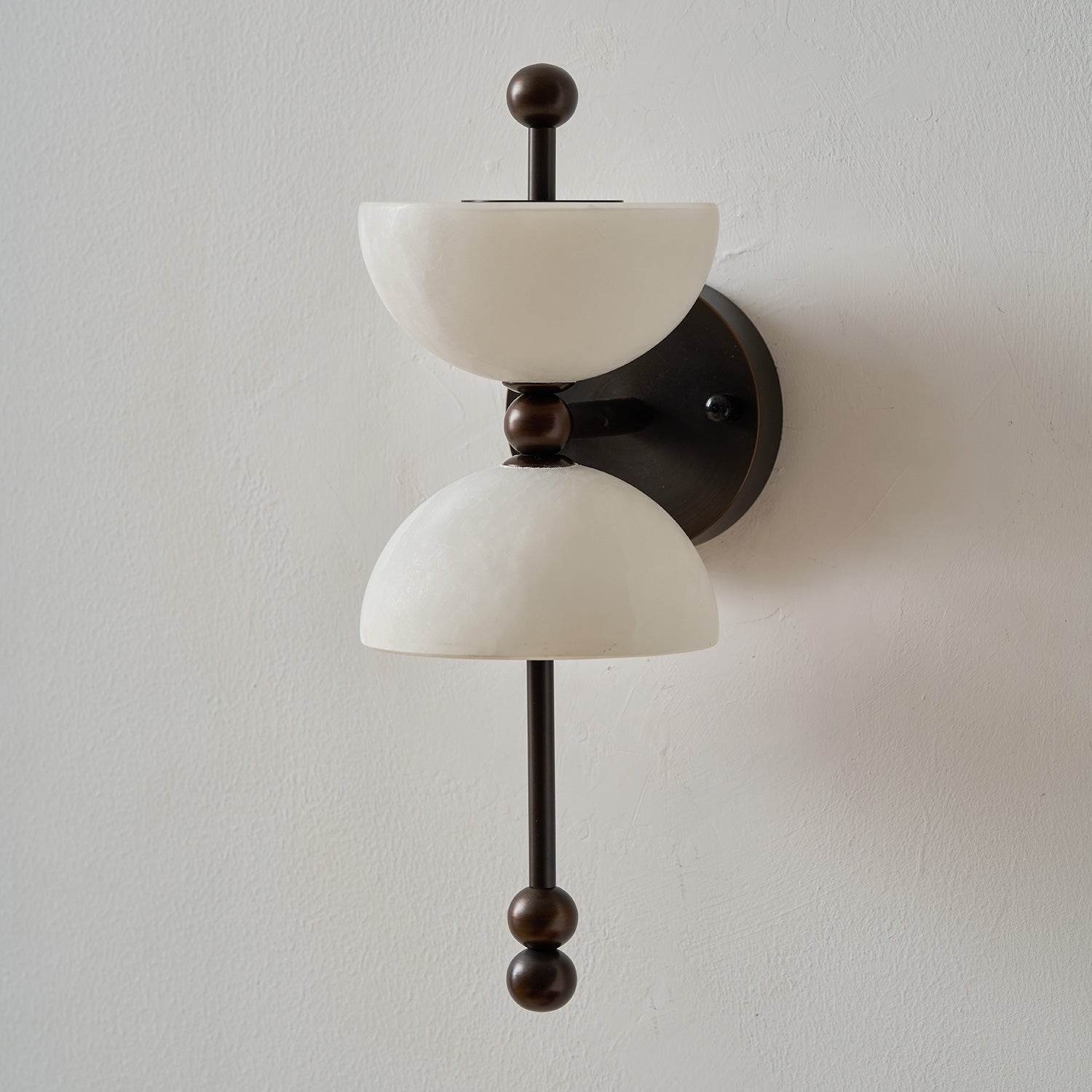 Lifestyle image featuring the Lyra Wall Lamp in a bedroom.