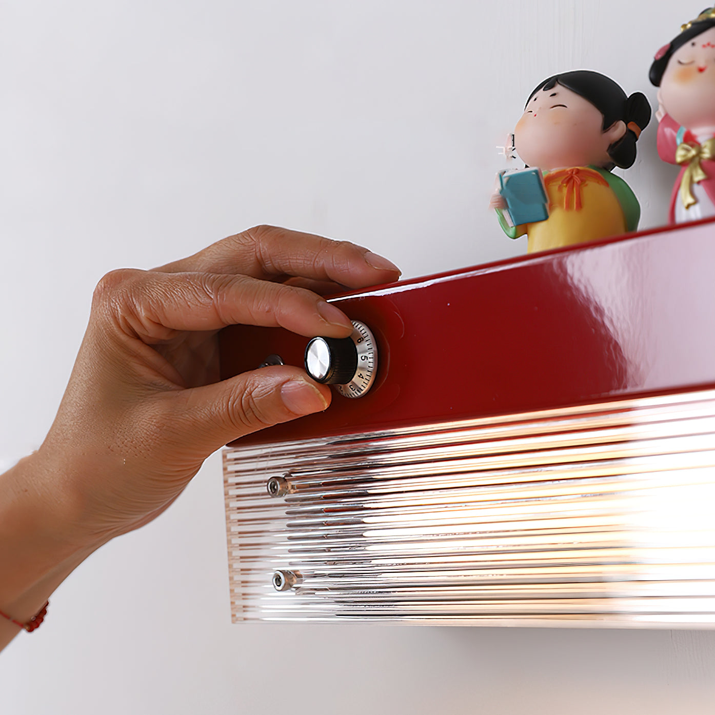 Angled view of the orange Totem Wall Lamp, highlighting its shelf feature.
